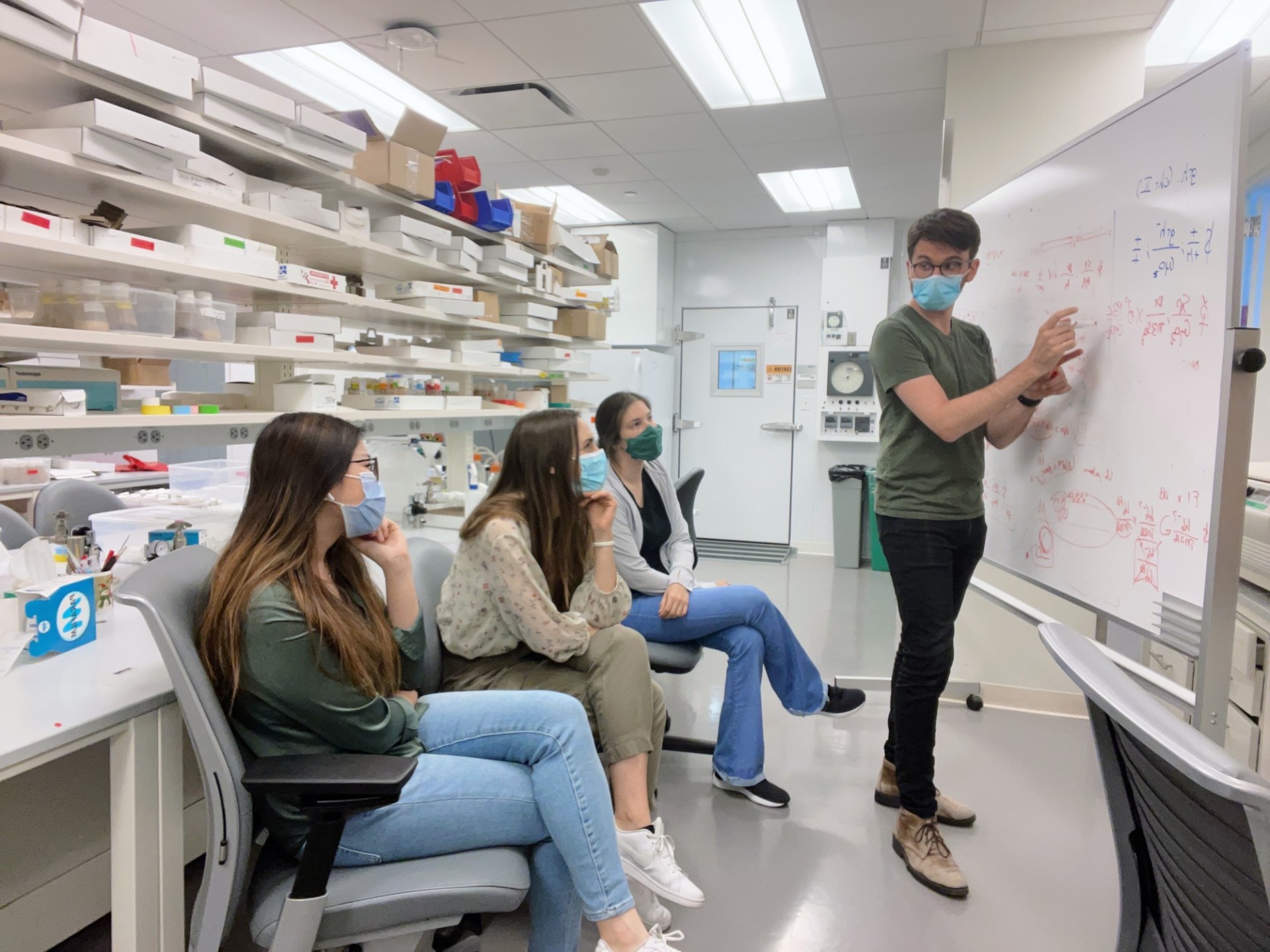 Tanguy explaining something to the lab in front on a whiteboard 