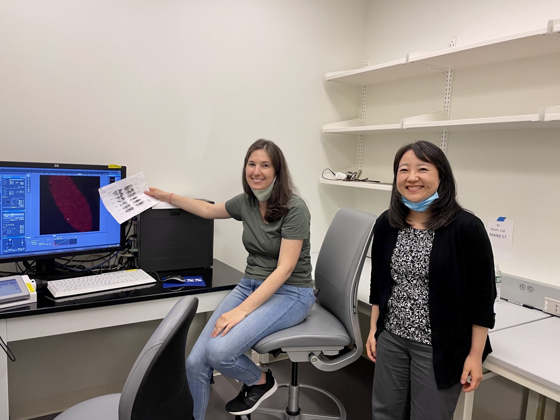 Gillie and Minoree next to computer display showing stained embryo